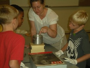 K-12 Curriculum Coordinator Laura Sparaco explores artifacts with the Young Historians.