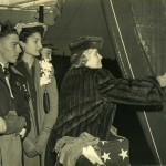 Billy Michal (foreground) looks on as Mrs. Gerhauser, wife of Delta President, chistens the Liberty ship.
