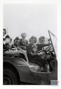 US Army nurses riding in a jeep during WWII. Gift of Bob Harris, from the collection of The National World War II Museum.