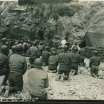 Original caption: Signal Corps radio telephoto. Italy. Steel helmeted American soldiers kneel in reverence at Easter morning services on the Italian Front. Father Gregory R. Kennedy, Dubuque, Iowa, says Mass for these men who have left the safety of their nearby foxholes to attend. Italy. 9 April 1944