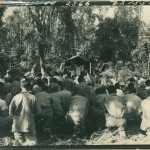 Original caption: Members of the 182nd Inf fighting on Bougainville, go forward to take communion Easter Sunday at services conducted by Capt Lawrence Brock, Jesuit father, from Charleston, Mass.