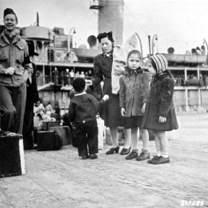 Aleutian American woman and children prepare to leave Dutch Harbor, Alaska for internment camps in 1942. Courtesy of the National Archives and Records Administration. 