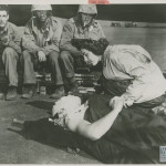 FLIGHT NURSE AIDS WOUNDED ON IWO JIMA BATTLEFIELD ON 6 MARCH 1945. U.S. Navy Official photograph, Gift of Charles Ives, from the collection of The National World War II Museum.
