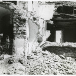 U.S. serviceman and young, Italian boy surveying bomb damage in Italy in 1944
