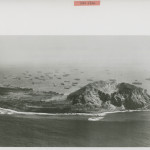 An aerial view of Iwo Jima with landing craft ready for invasion. From the collection of the NWWII Museum