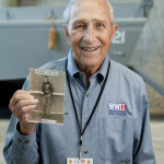 Bet Stolier holding a photo of himself during his World War II service.